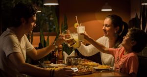 Family celebrating and eating at a restaurant together.