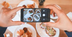 Image of a person taking a photo of their food.