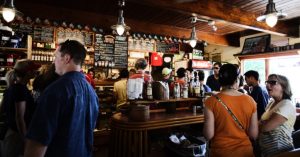 Image of a group of people forming a line in a cozy coffee shop.