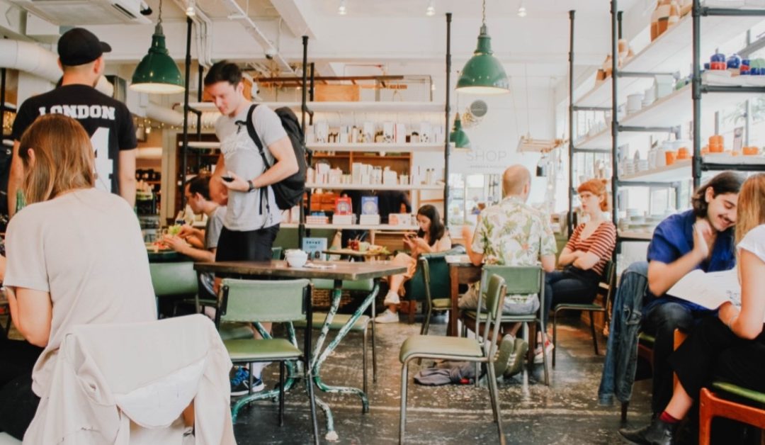 Image of a busy cafe with people eating, walking, and talking.