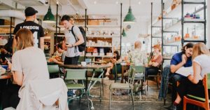 Image of a busy cafe with people eating, walking, and talking.