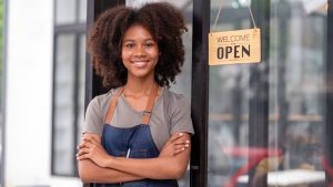 a woman standing near an open sign on a door